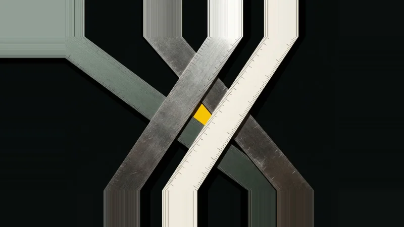 Overhead view of three metal straightedges crossing off-centre, leaving a small yellow triangle of misalignment.