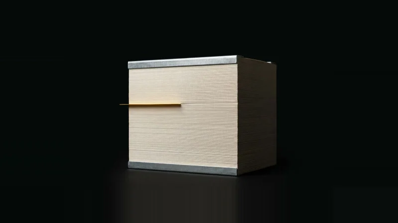 A block of thousands of laminated document pages milled flat, one yellow index tab protruding, on black.