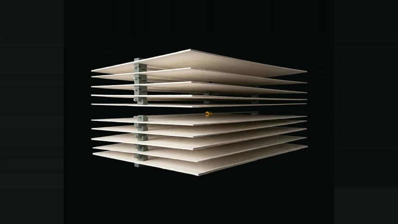 Exploded stack of pale drawing sheets on metal rods, one slot in the sequence left empty and ringed in yellow.