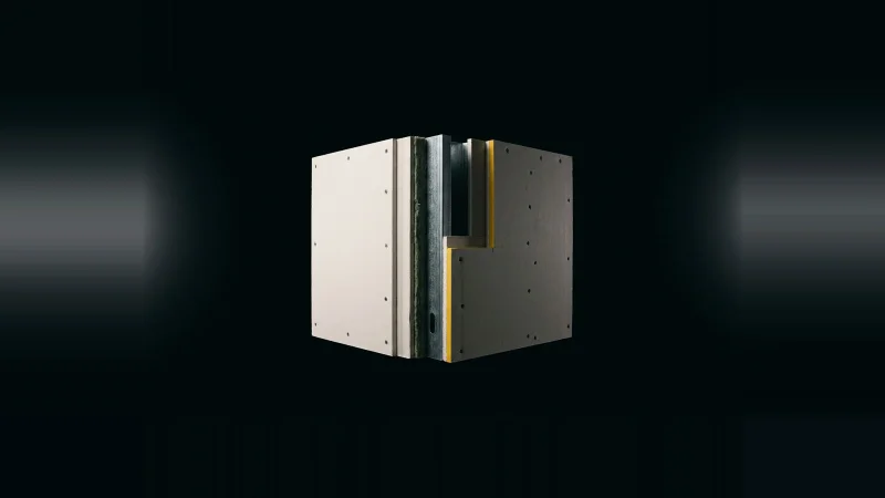 Cutaway fire-rated partition specimen, three gypsum layers one side, two the other, yellow marker on the gap