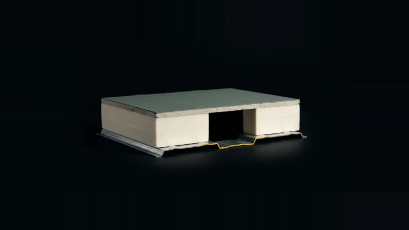 Cross-section sample of a layered roof assembly on black, with one board layer missing, lit hard from one side.