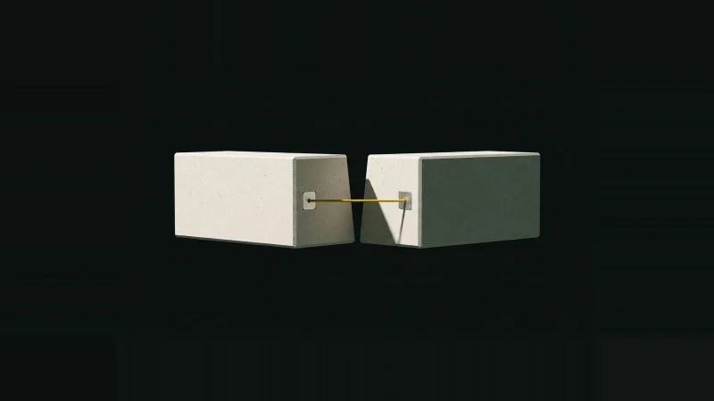 Two pale concrete blocks with a wedge-shaped gap between them, bridged by a single taut yellow wire, on black.