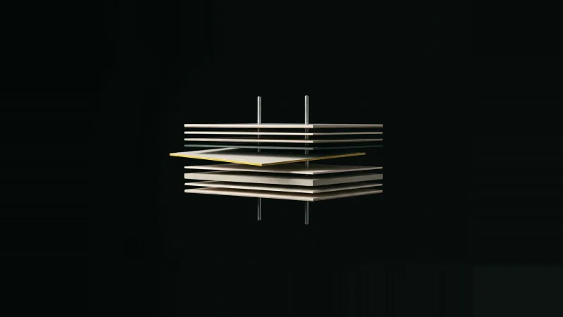Exploded stack of pale sheet layers threaded on metal pins, one layer slipped off and edge-lit yellow