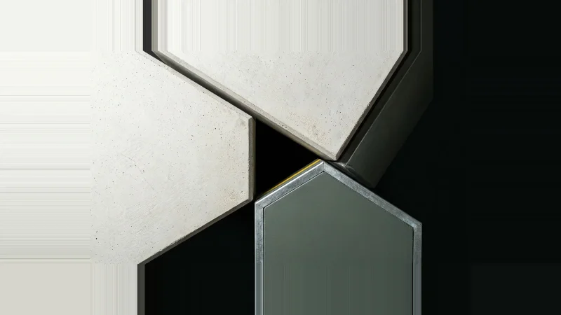 Overhead view of three pale concrete panels meeting with a narrow black void between them, one edge lit yellow.