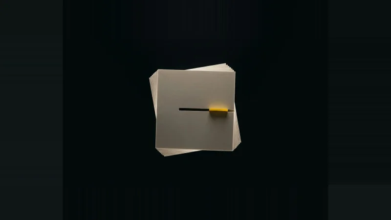 Overhead view of a small fanned stack of off-white paper sheets in blackness, one sheet missing, marked by a yellow tab