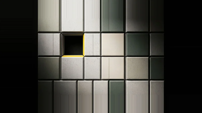 Overhead view of a pale concrete tile grid with one tile missing, the void's edge lit in yellow.