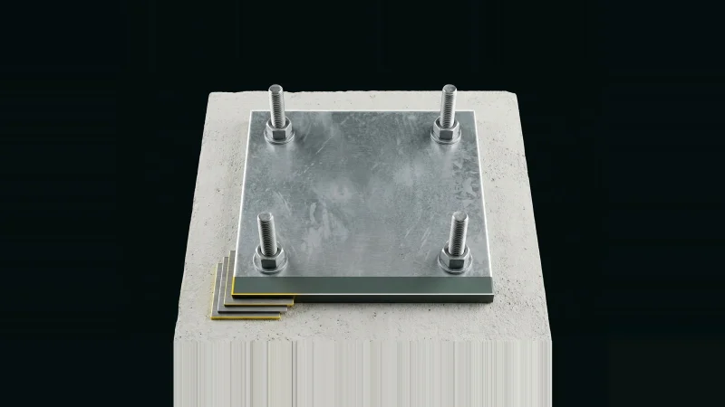 Overhead view of a galvanised steel column base plate on concrete, anchor bolts and stacked leveling shims lit at their edges