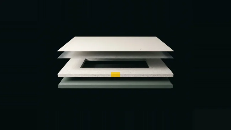 Overhead exploded stack of paper, metal, concrete and insulation panels with one layer missing and a yellow edge tab