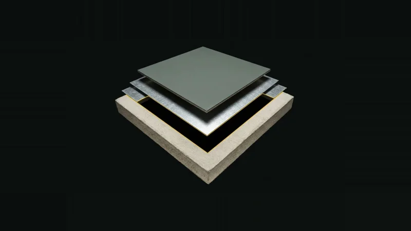 Overhead view of a stacked roof-assembly sample with one layer missing, lit only at its edges against black.
