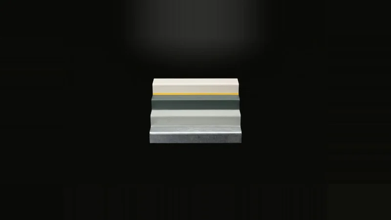 A small stepped steel test panel showing four coating layers, from bare metal to off-white finish, on black.