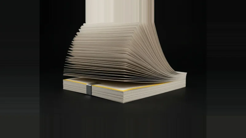 A stack of off-white paper sheets, square at the base but fanning wide above one misaligned sheet edged in yellow.
