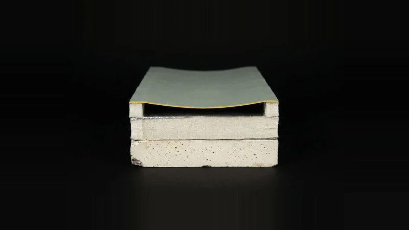 Close-up cross-section of a roof assembly on black, with an empty gap where the cover board layer should be.