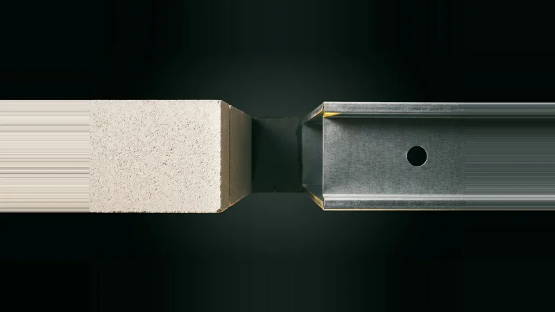 Close-up of a concrete block wall edge meeting a galvanised steel stud track with an unsealed gap between them.