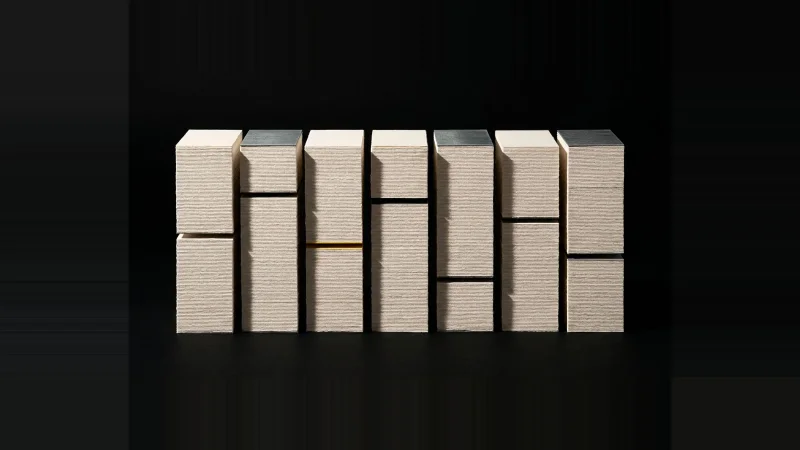 Eight stacks of pale cards with perfectly level tops but hidden gaps inside, one gap lit yellow.