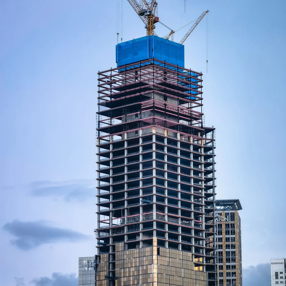 A tower under construction with a crane above it